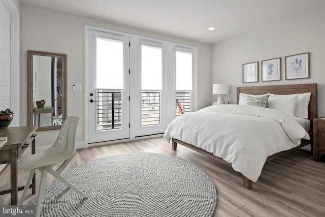 bedroom with access to outside, recessed lighting, and wood finished floors