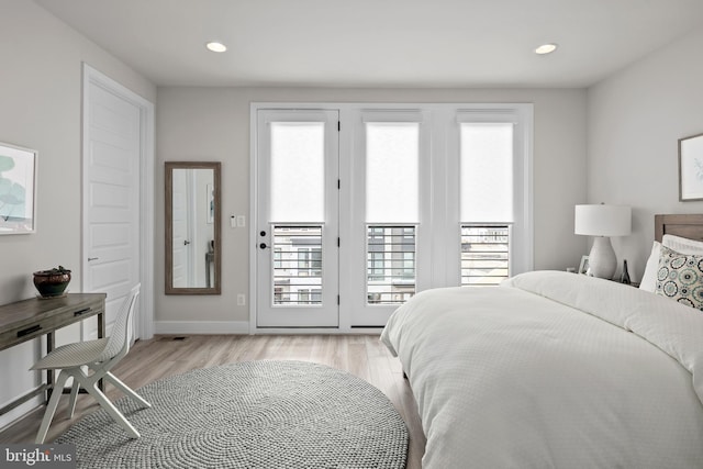 bedroom featuring access to outside, multiple windows, and light wood-style floors