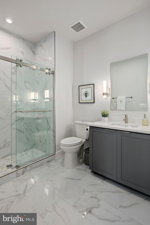 bathroom featuring visible vents, toilet, marble finish floor, a marble finish shower, and vanity