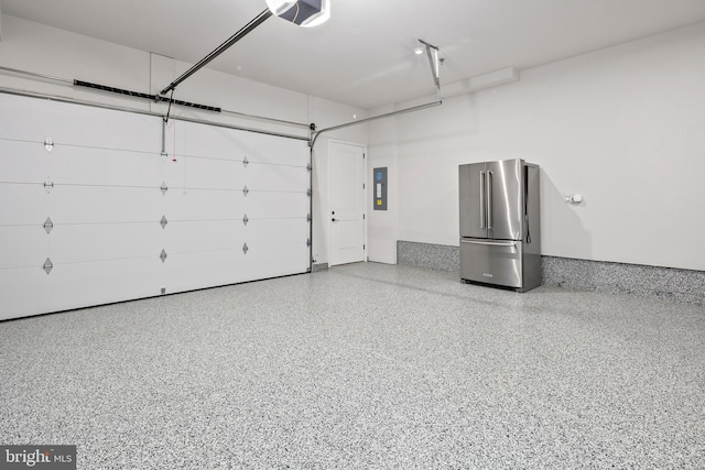 garage featuring electric panel, a garage door opener, and freestanding refrigerator