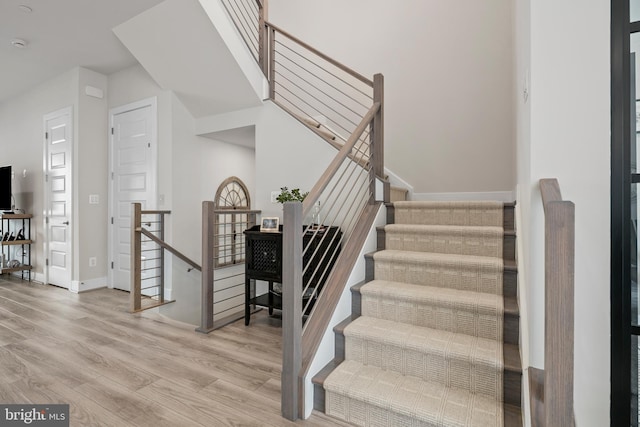 staircase with baseboards and wood finished floors