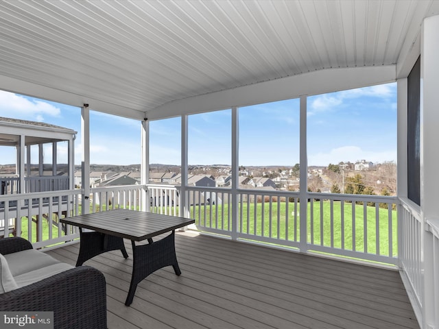 sunroom / solarium featuring a residential view and a healthy amount of sunlight