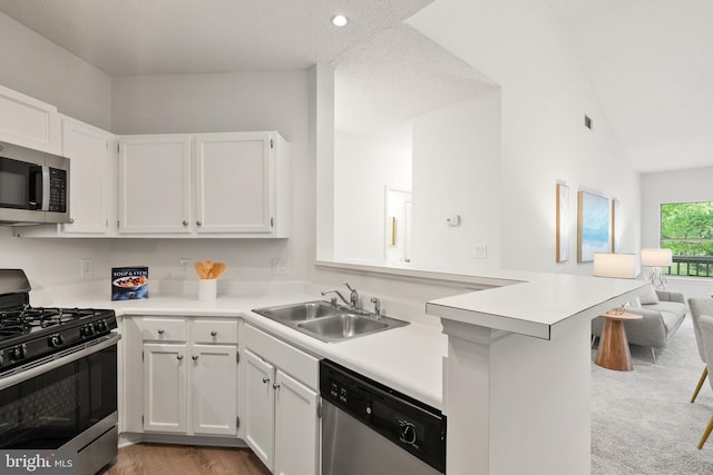 kitchen with a sink, light countertops, white cabinets, and stainless steel appliances