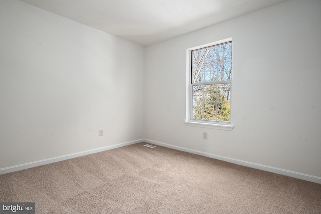 carpeted empty room featuring visible vents and baseboards