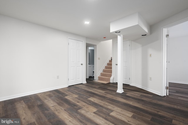 finished basement with dark wood-style flooring, stairway, and baseboards