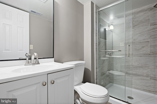 bathroom featuring toilet, a stall shower, vanity, and visible vents