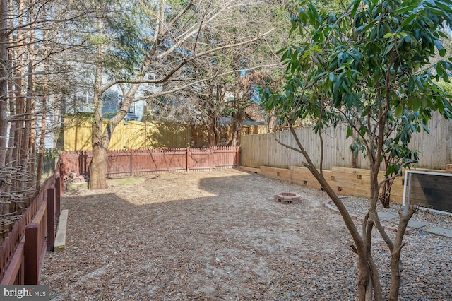 view of yard with a fire pit and a fenced backyard