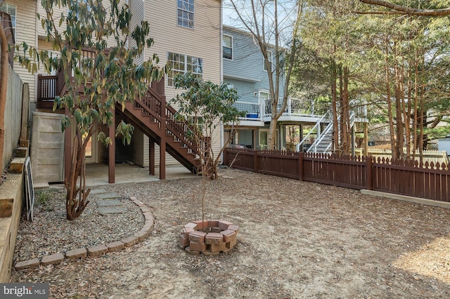 view of yard with a fire pit, stairway, and a fenced backyard