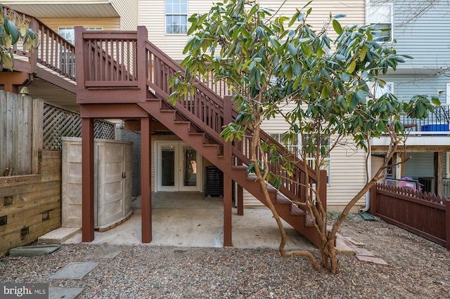 exterior space featuring stairs, french doors, and fence