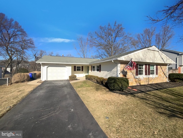 view of front facade featuring a garage, driveway, and a front lawn