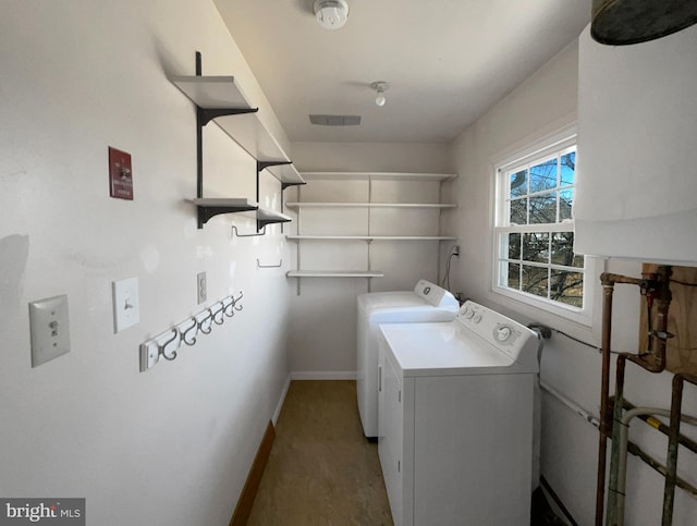 laundry area with laundry area, water heater, baseboards, and washing machine and clothes dryer