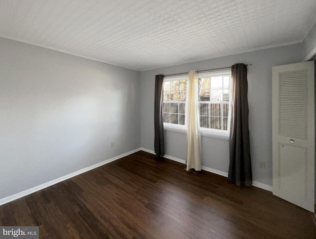 unfurnished room featuring baseboards and dark wood-style flooring