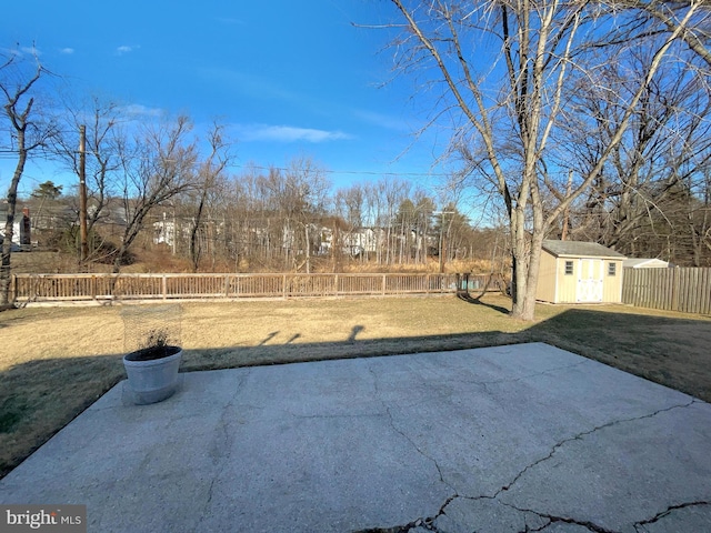 view of yard with a storage shed, a fenced backyard, an outdoor structure, and a patio