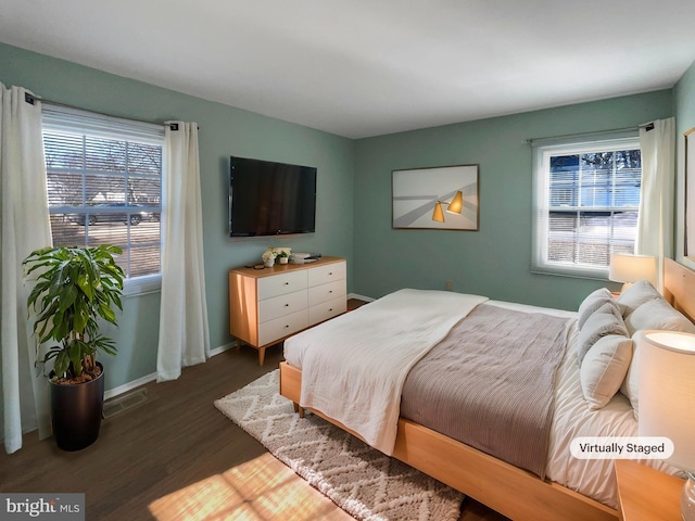 bedroom featuring baseboards, visible vents, and dark wood finished floors