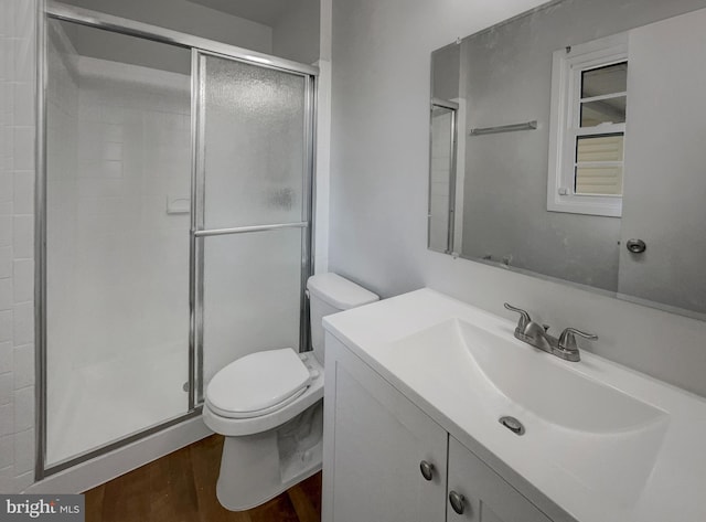 full bath with toilet, a stall shower, wood finished floors, and vanity