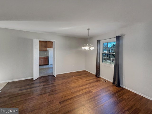 unfurnished dining area featuring an inviting chandelier, baseboards, and dark wood-style flooring