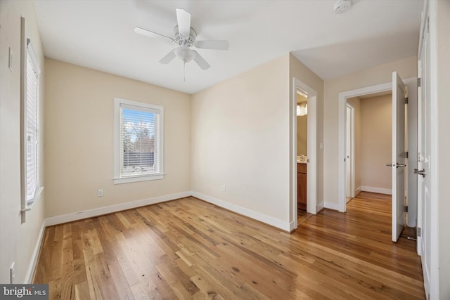 unfurnished bedroom featuring ceiling fan, light wood-style flooring, and baseboards