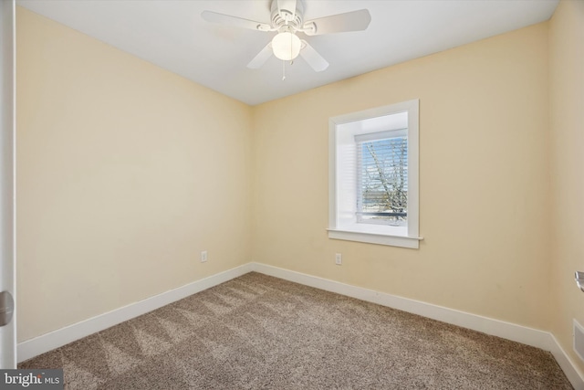 carpeted spare room with ceiling fan and baseboards