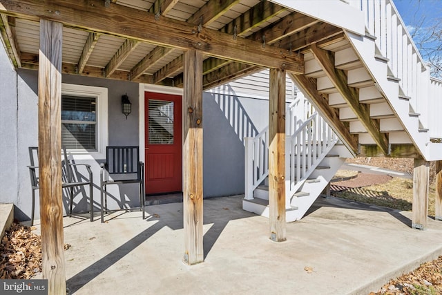 entrance to property featuring a patio and stucco siding