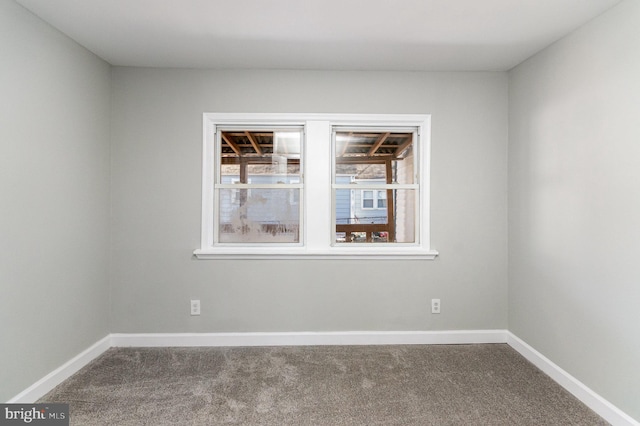 spare room with carpet and baseboards