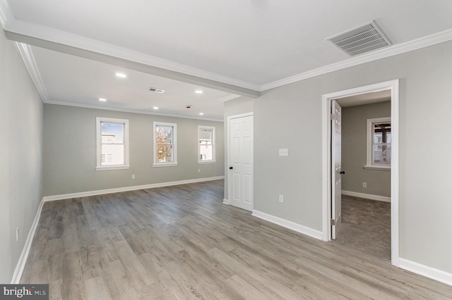 empty room with light wood-style floors, baseboards, and visible vents