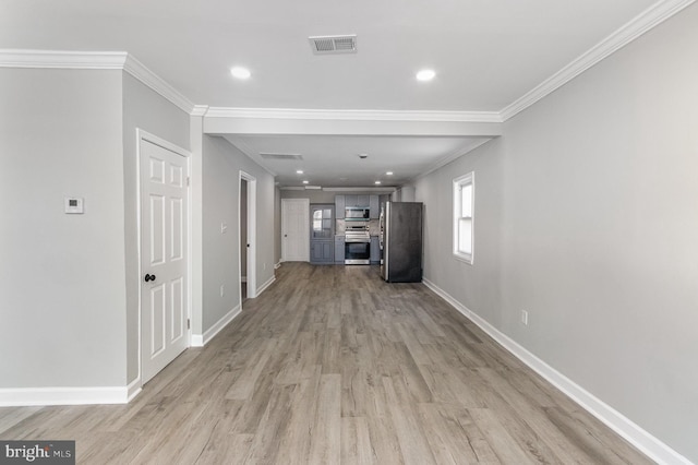 unfurnished living room with ornamental molding, light wood-type flooring, visible vents, and baseboards