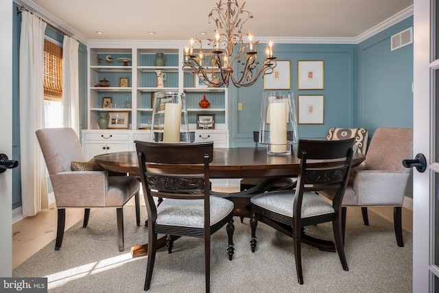 dining area featuring a notable chandelier, a decorative wall, visible vents, and crown molding