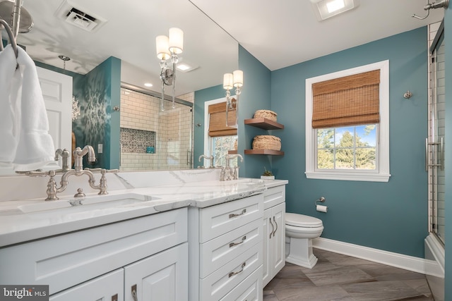 bathroom featuring visible vents, a sink, toilet, and an enclosed shower