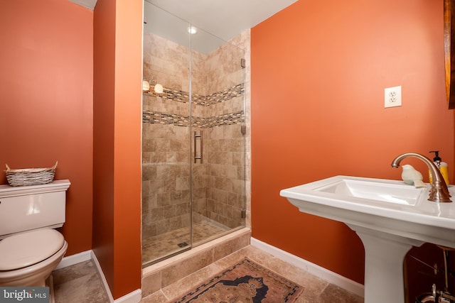 full bathroom with a stall shower, tile patterned flooring, baseboards, and toilet