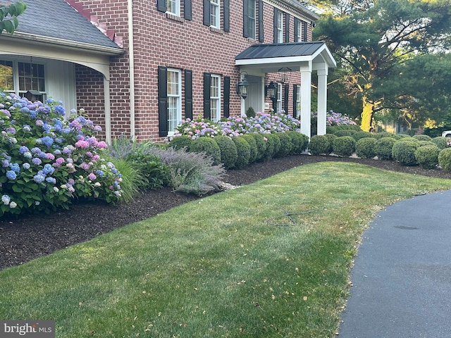 view of property exterior featuring a lawn and brick siding