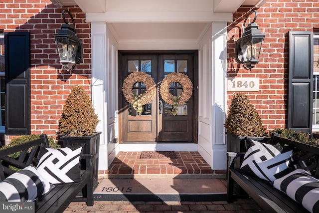 entrance to property featuring french doors and brick siding