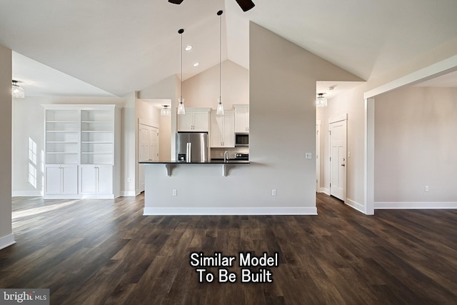 kitchen with white cabinetry, appliances with stainless steel finishes, dark countertops, a kitchen bar, and decorative light fixtures