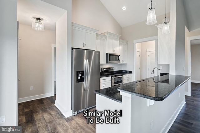 kitchen with appliances with stainless steel finishes, decorative light fixtures, a peninsula, white cabinetry, and a sink