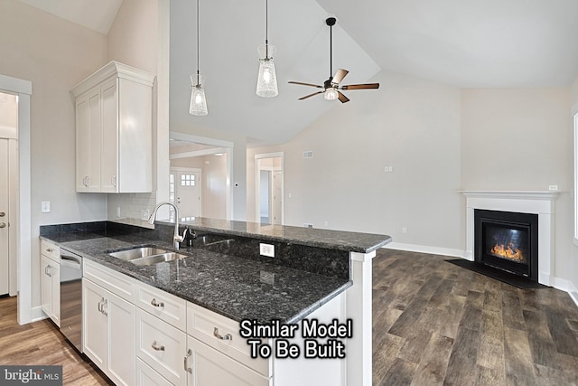 kitchen with stainless steel dishwasher, open floor plan, white cabinets, a sink, and dark stone countertops