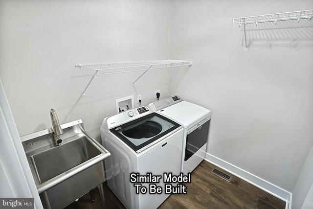 laundry room with laundry area, visible vents, dark wood-type flooring, washing machine and dryer, and a sink