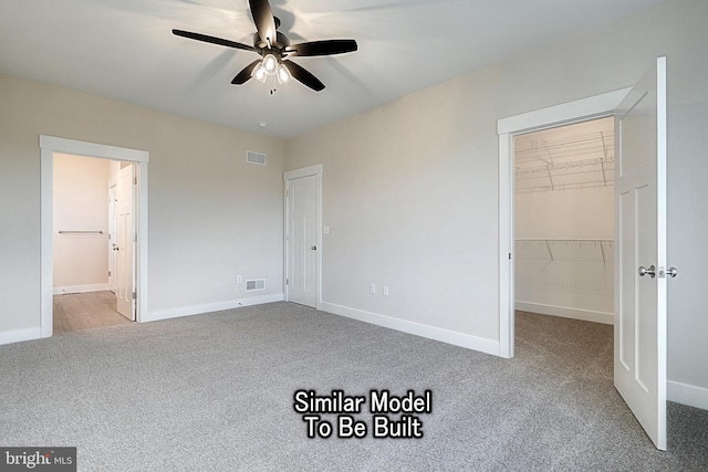 unfurnished bedroom featuring baseboards, a spacious closet, visible vents, and light colored carpet