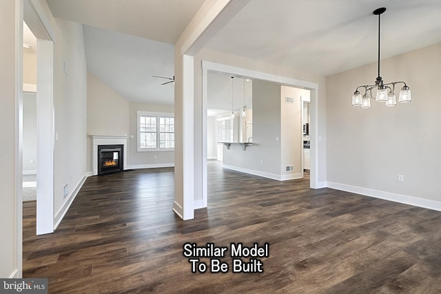 unfurnished living room with a glass covered fireplace, vaulted ceiling, dark wood finished floors, and baseboards