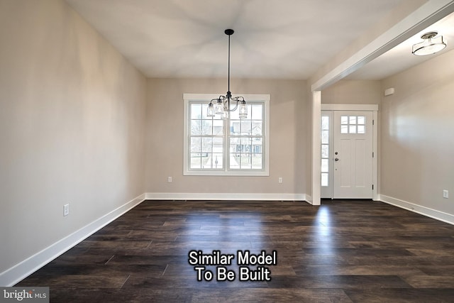 foyer entrance featuring dark wood finished floors, baseboards, and an inviting chandelier