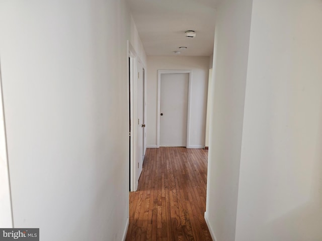 hallway featuring wood finished floors and baseboards