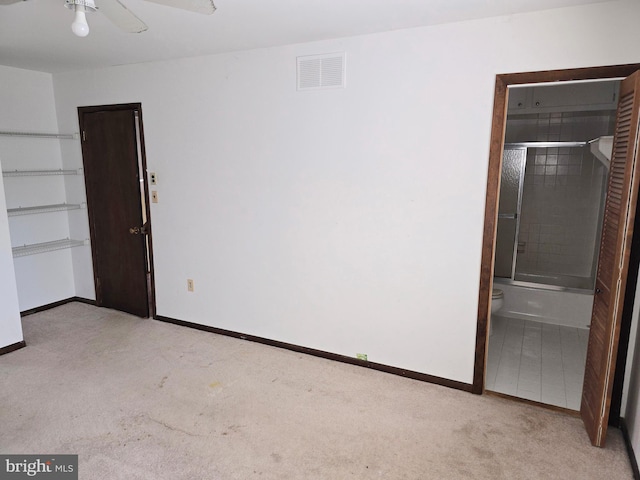 unfurnished bedroom featuring light carpet, ensuite bathroom, visible vents, and baseboards