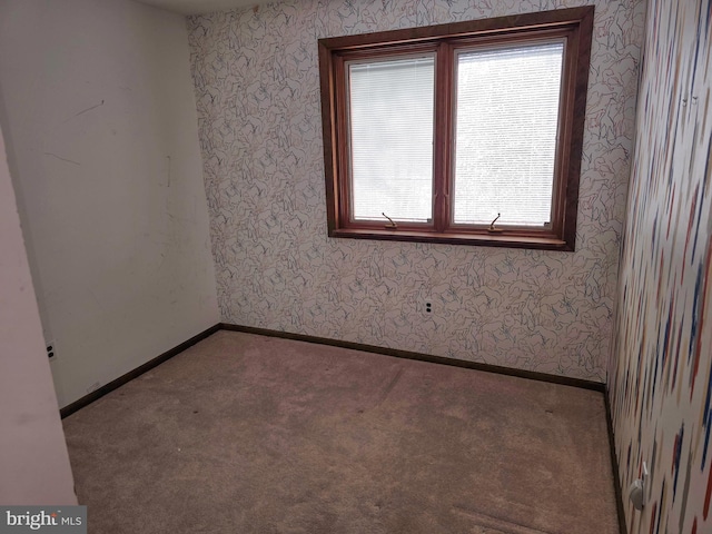 carpeted spare room with wallpapered walls and baseboards