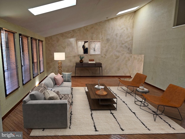 living area featuring vaulted ceiling with skylight and wood finished floors