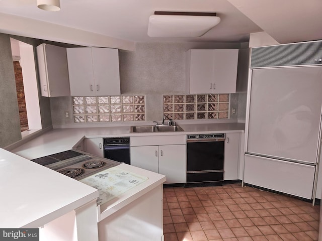 kitchen featuring light countertops, white cabinets, a sink, paneled built in refrigerator, and dishwasher