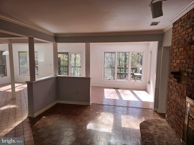 interior space with ornamental molding, a wealth of natural light, visible vents, and baseboards