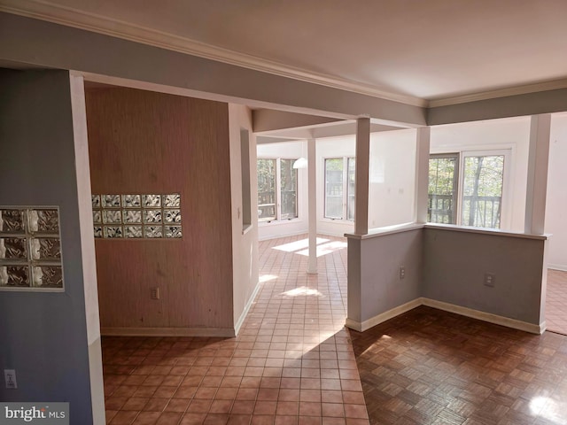 empty room featuring crown molding and baseboards