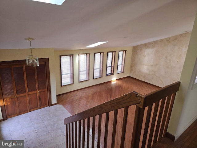 entryway featuring light wood finished floors, a skylight, and baseboards