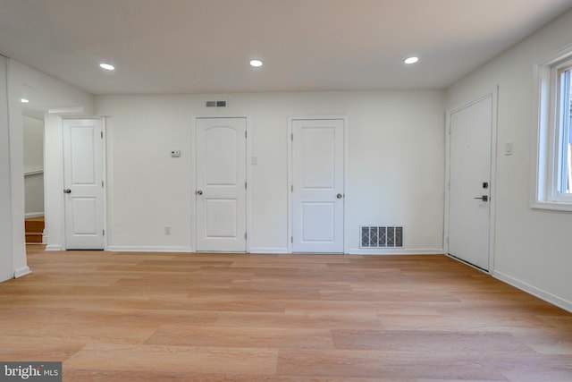 empty room featuring light wood-style floors, recessed lighting, and visible vents