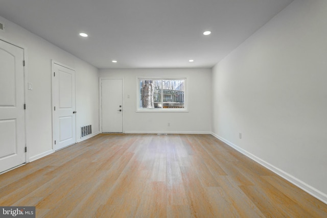 empty room with baseboards, light wood-type flooring, visible vents, and recessed lighting