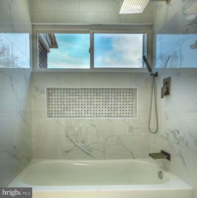 bathroom featuring a healthy amount of sunlight and bathing tub / shower combination