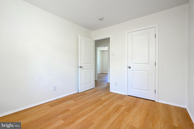 unfurnished bedroom featuring light wood-type flooring and baseboards